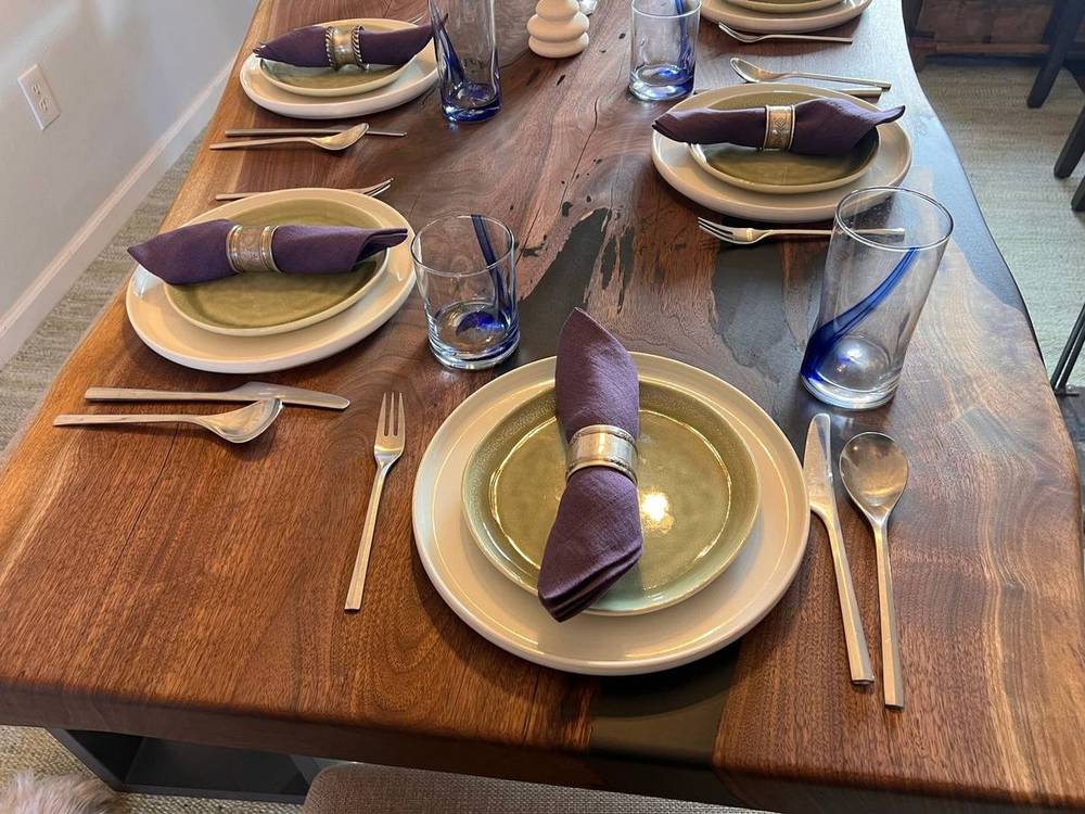The walnut dining table set with plates and candles