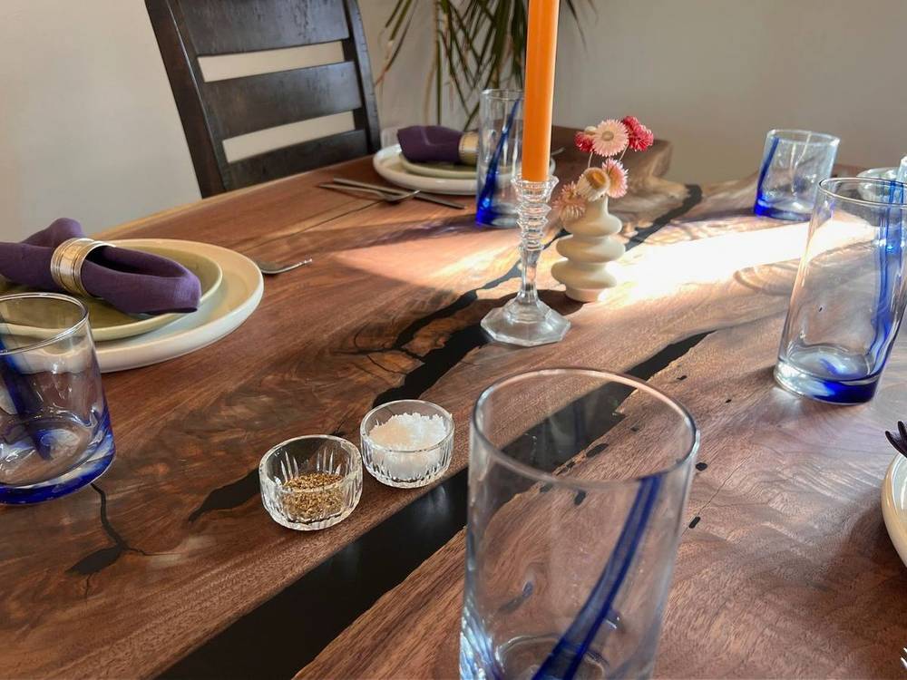 Live edge walnut slab finished as a dining table top, showing natural edge and grain