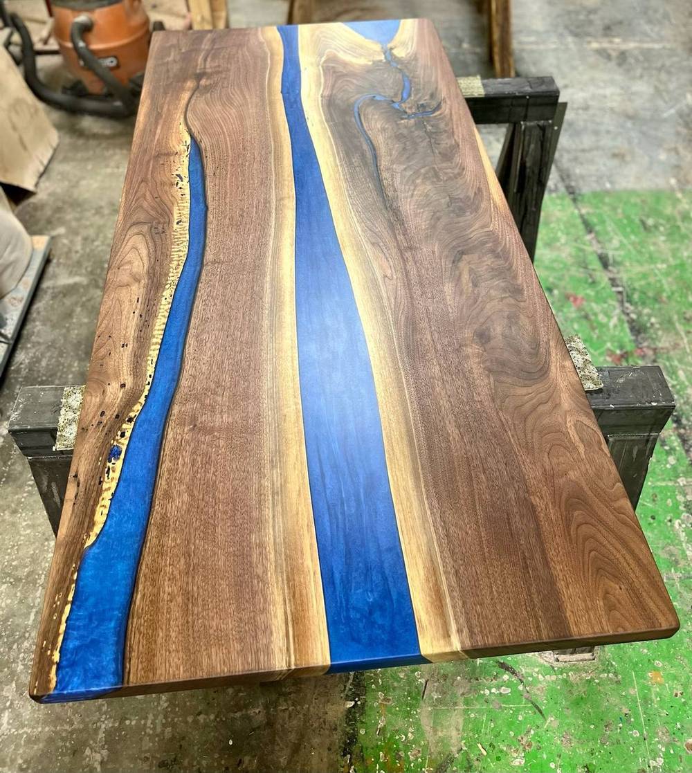 Blue epoxy river table made from two walnut slabs, shown at full length