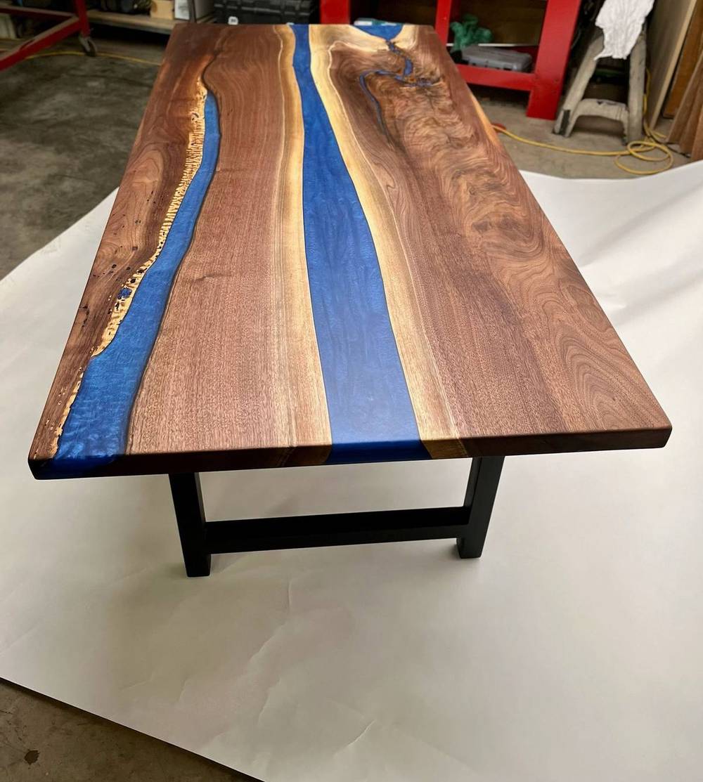The blue river walnut table photographed against a white backdrop