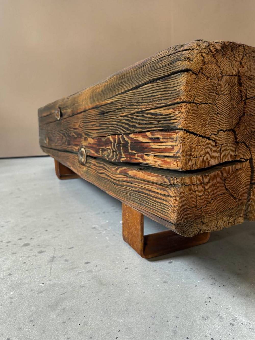 Reclaimed beam bench photographed on a seamless backdrop, three-quarter view