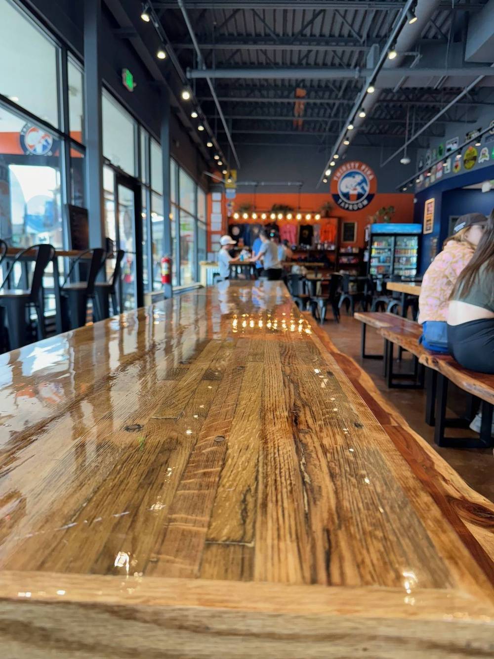 Long communal bar top made from reclaimed live edge slabs in a Denver brewery