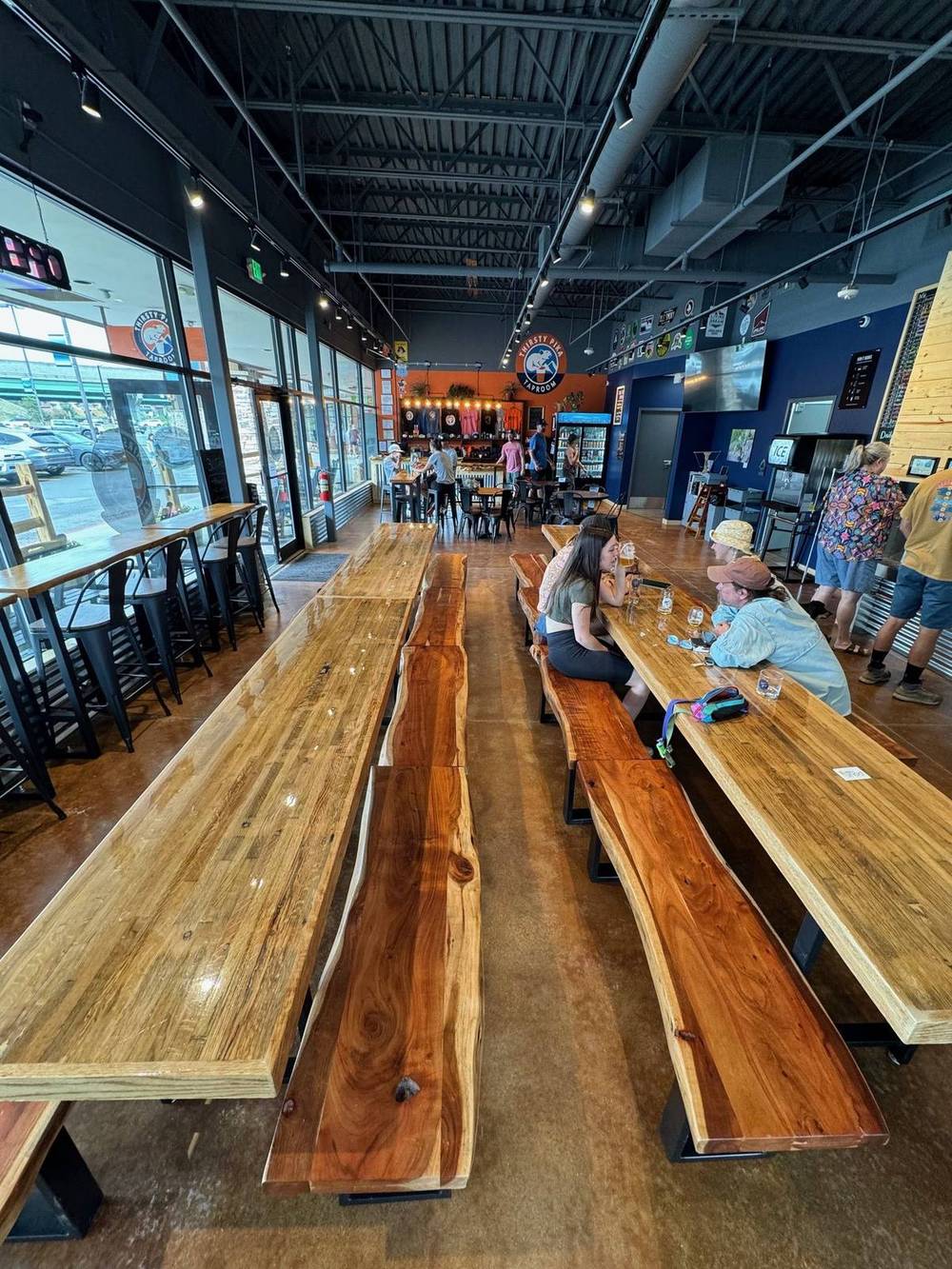 The brewery taproom in use with customers at the communal bar