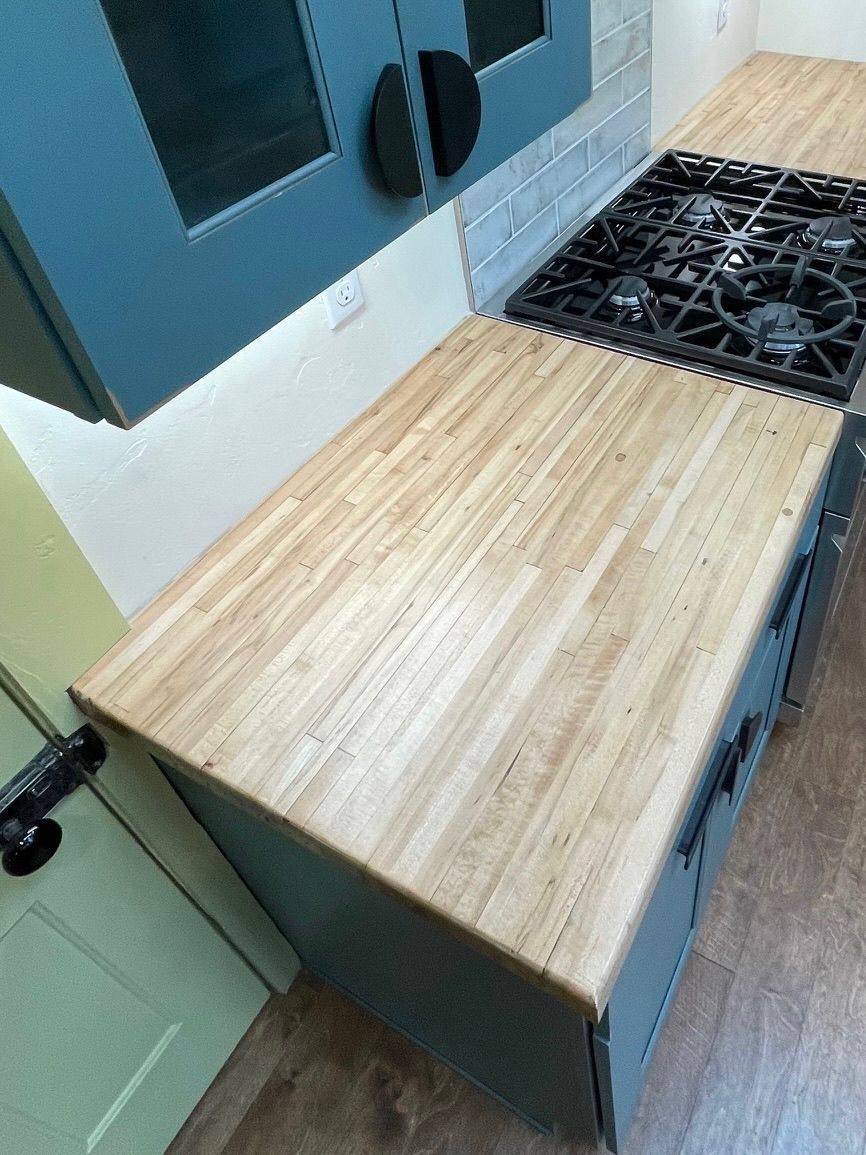 Teal kitchen island topped with reclaimed butcher block